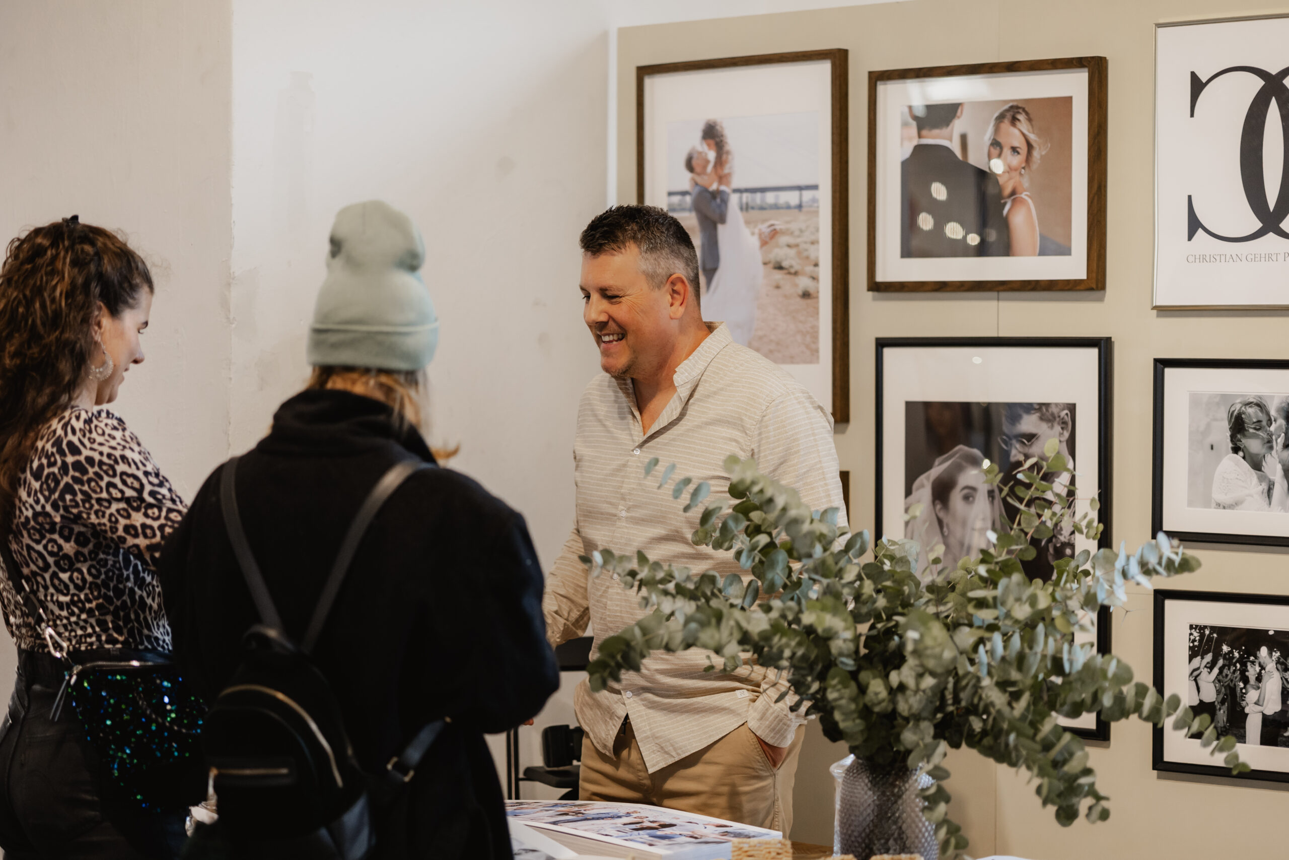 Hochzeitsfotograf im Gespräch mit möglichen Kunden auf seinem Messestand
